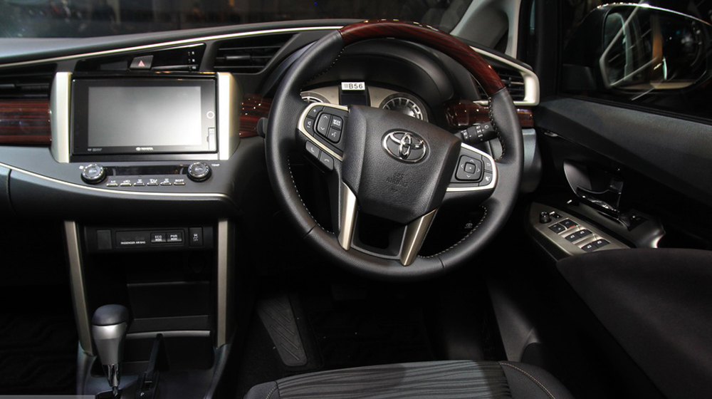 Toyota Innova 2016 sử dụng vô-lăng 4 chấu, bọc da và ốp vân gỗ sang trọng.